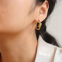 18K gold plated knot earrings worn close up Kuwait Jewelique